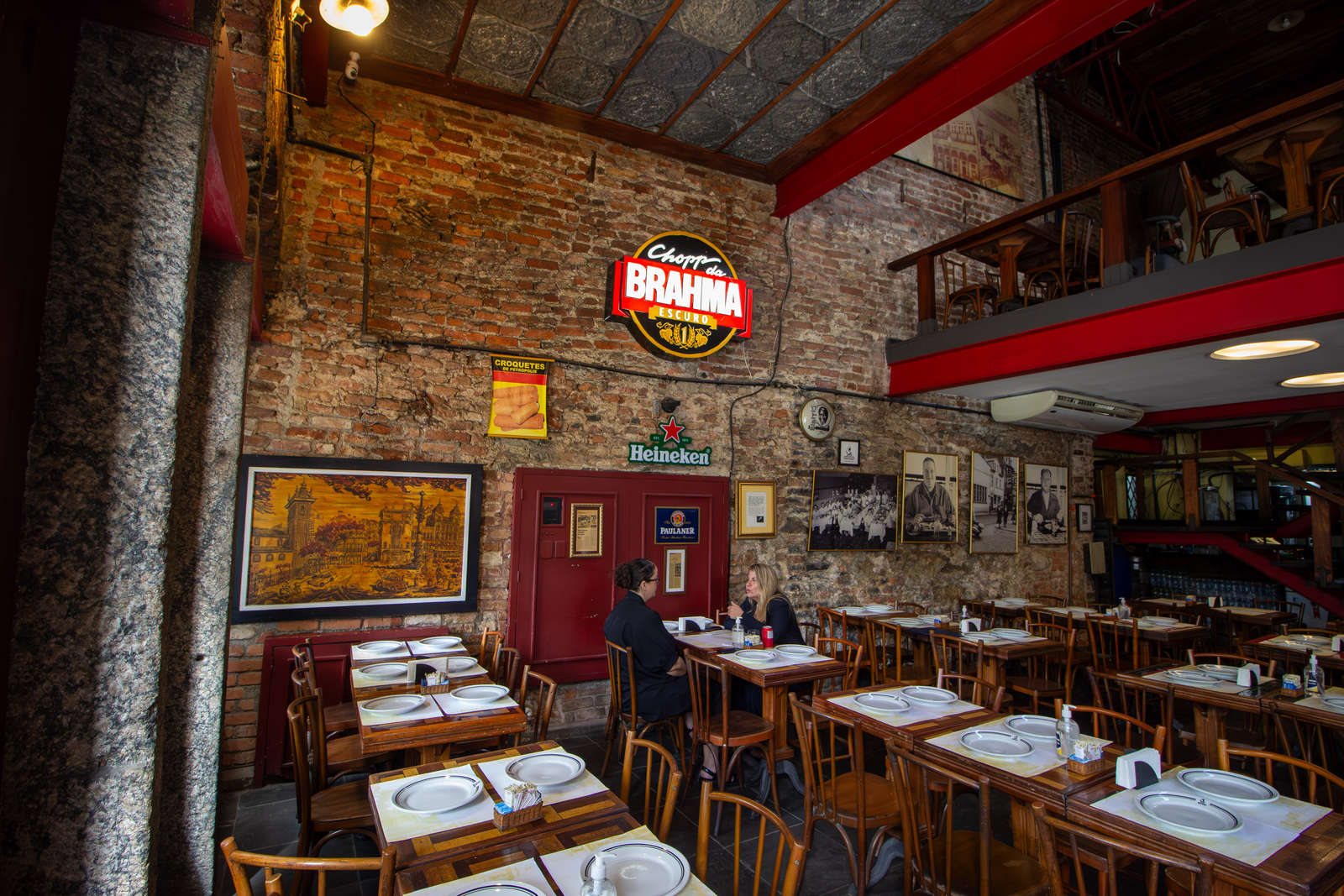 The historic dining room at Bar Ernesto with brick walls and wooden tables