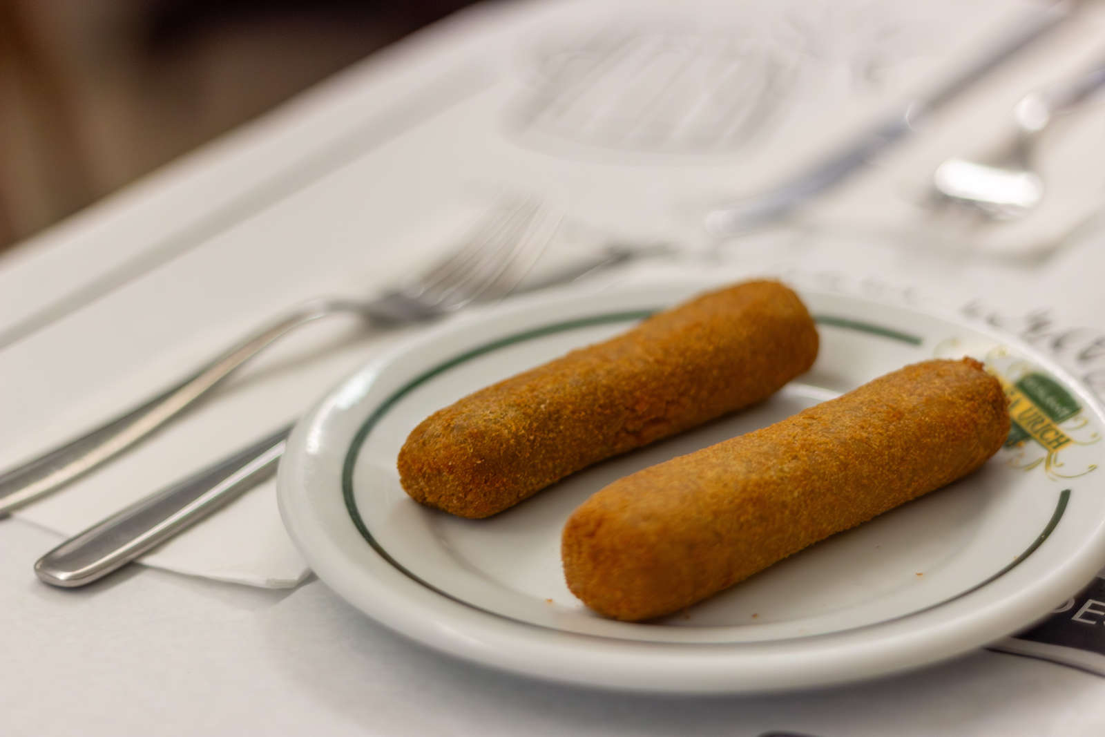 Casa Urich meat croquettes on a branded plate