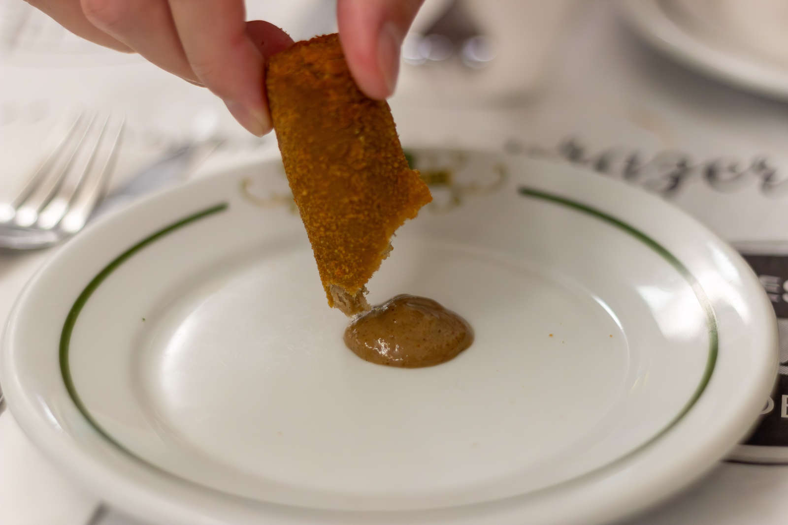A Casa Urich croquette with mustard