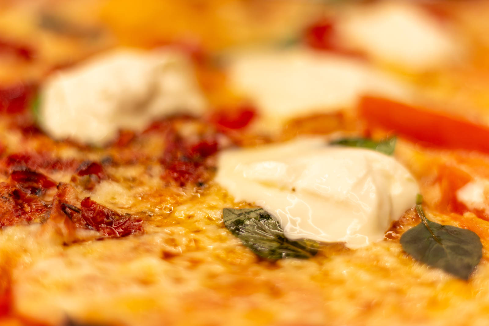 A close view of thin pizza dough topped with stracciatella at Zona Sul